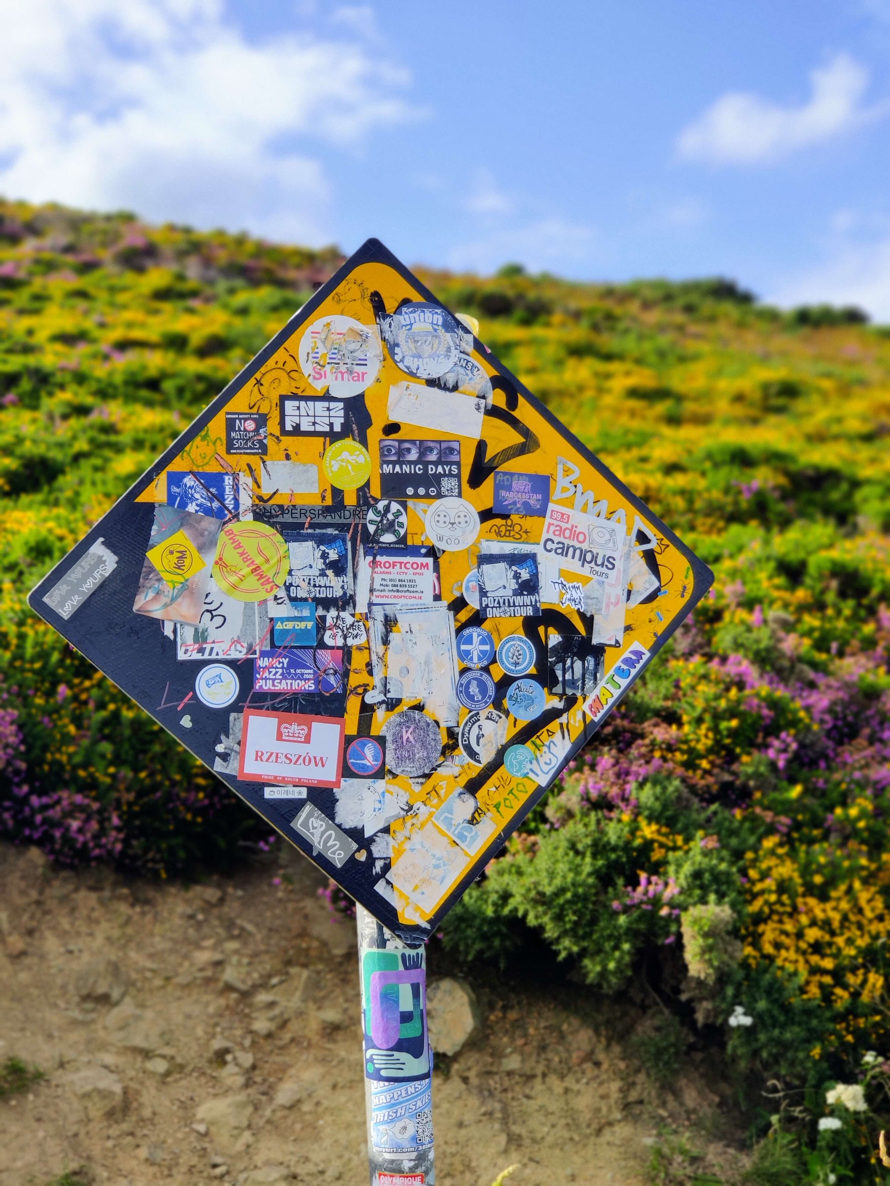Placa com muito adesivos de vários lugares do mundo em Howth, Irlanda